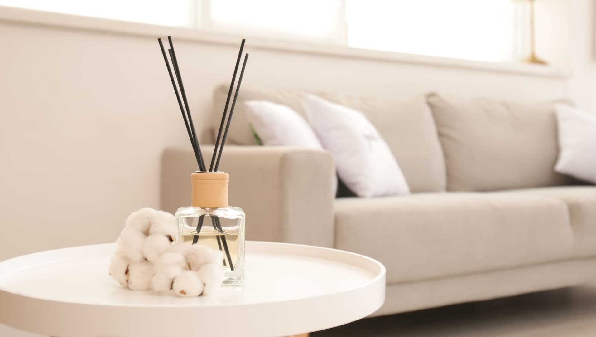 A cozy living room with reed diffusers on a wooden table